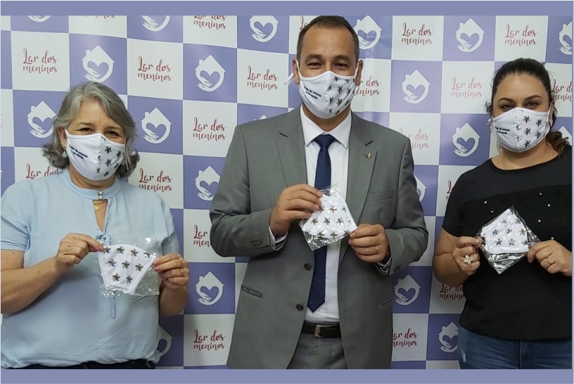 foto posada com o juiz e duas mulheres segurando as máscaras de proteção