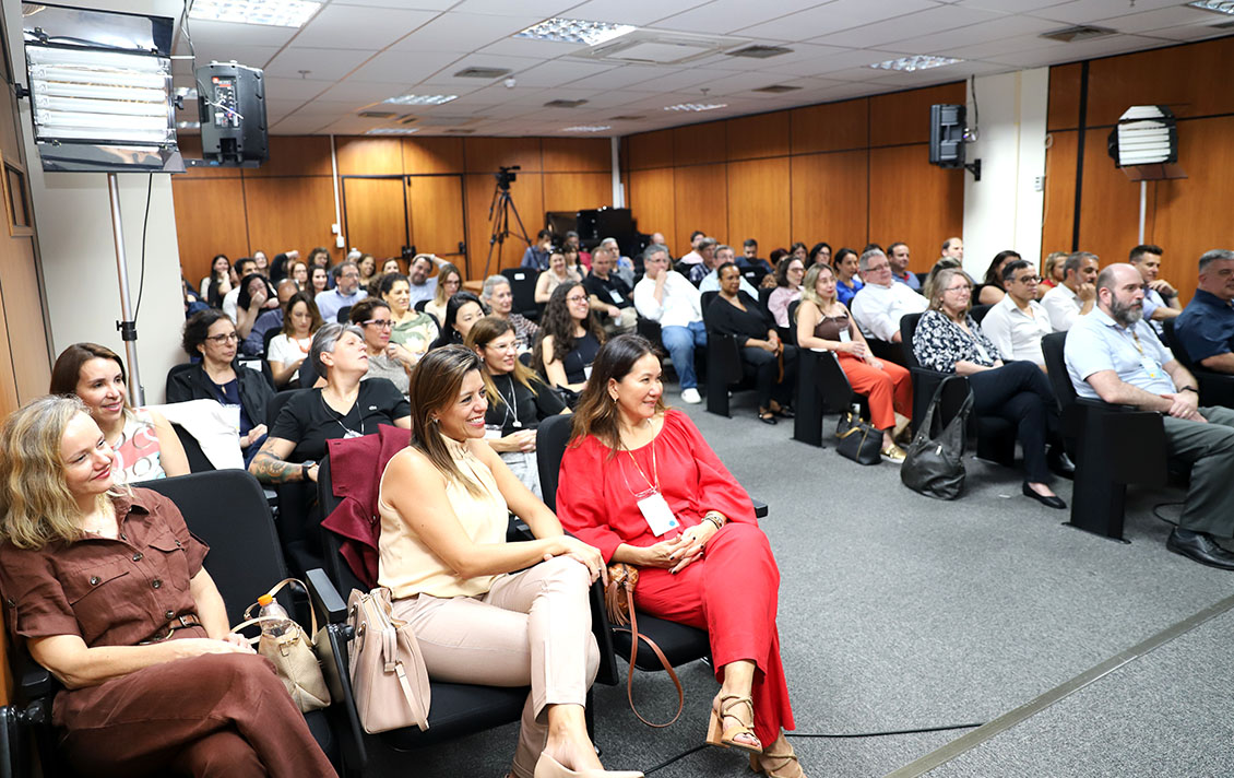 foto do público, com várias pessoas em um auditório, todas cadeiras ocupadas, atentos à fala da corregedora
