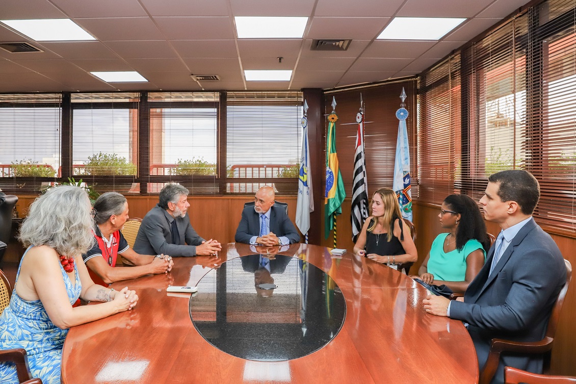 Dr. Samuel no centro ao fundo, com todos os participantes sentados à mesa oval, no Gabinete da Presidência