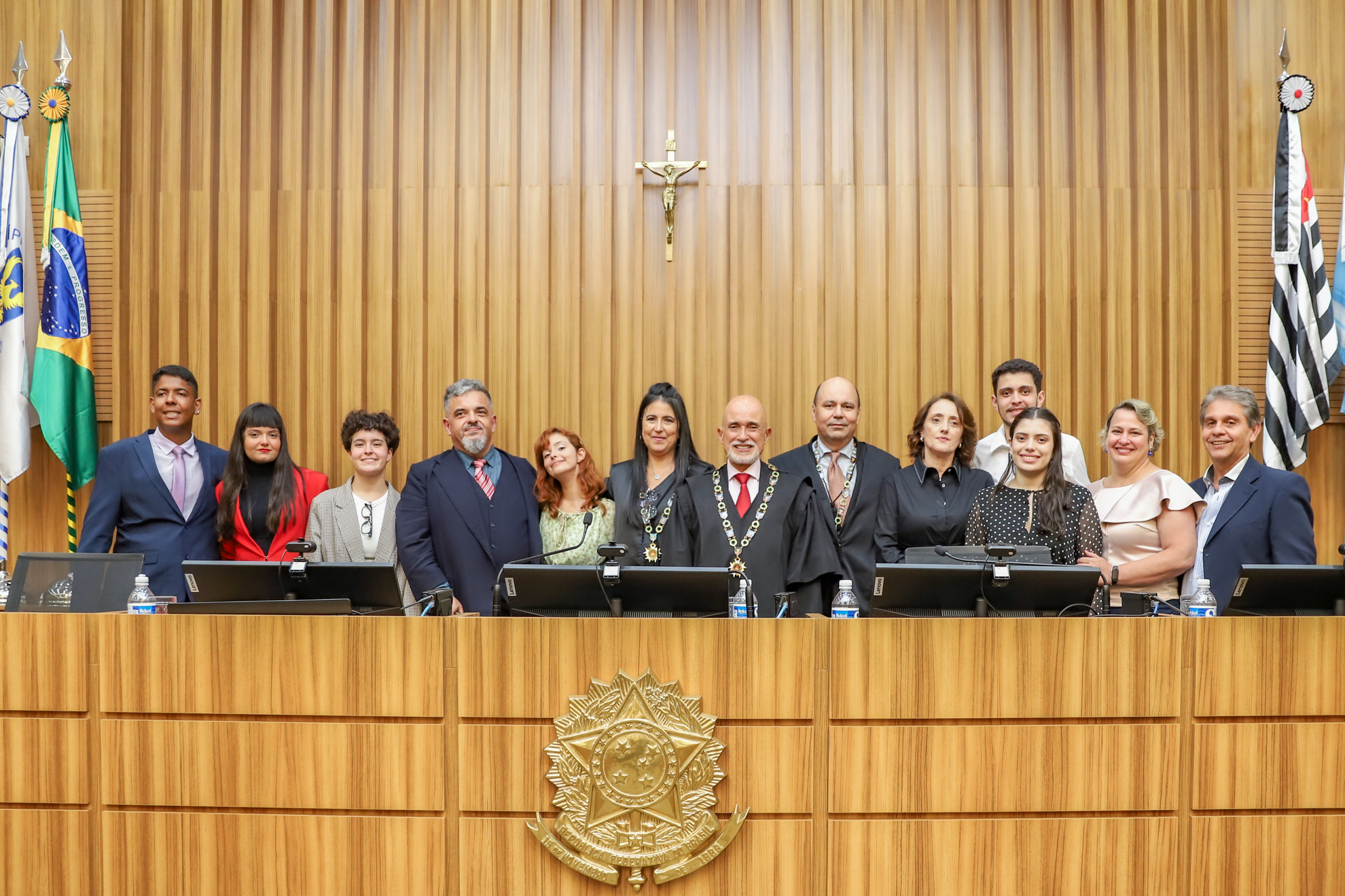 Dra. Ana e Dr. Marcelo com suas famílias e Dr. Samuel ao centro, na mesa alta do plenário revestido de madeira