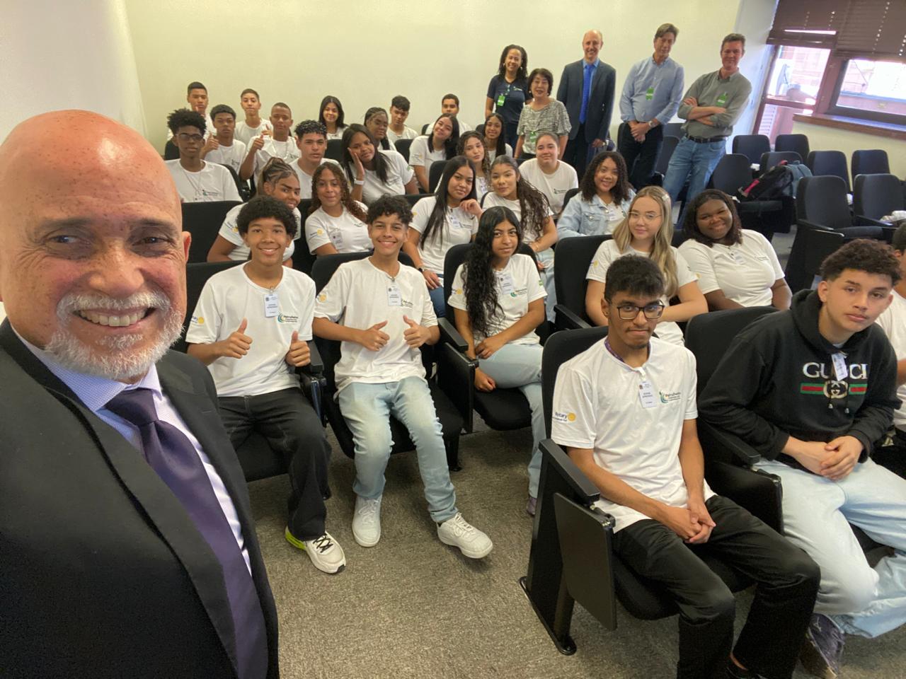 A foto retrata o doutor Samuel fazendo uma selfie com os jovens aprendizes.