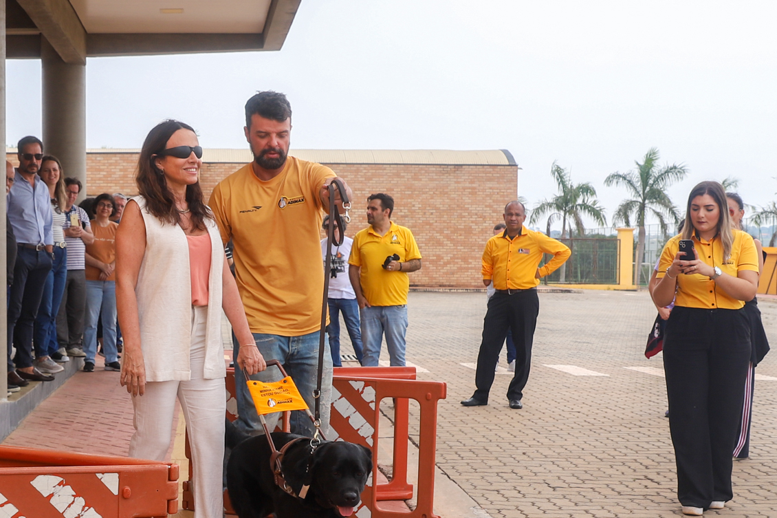 Magistrada com olhos vendados anda por um circuito com a ajuda de um cão-guia e um instrutor