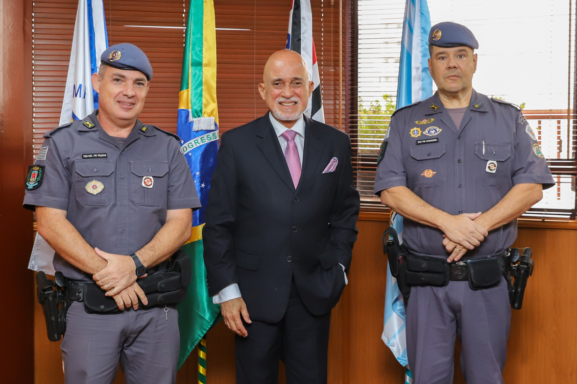 presidente Samuel e os representantes da PM no gabinete em frente as bandeiras