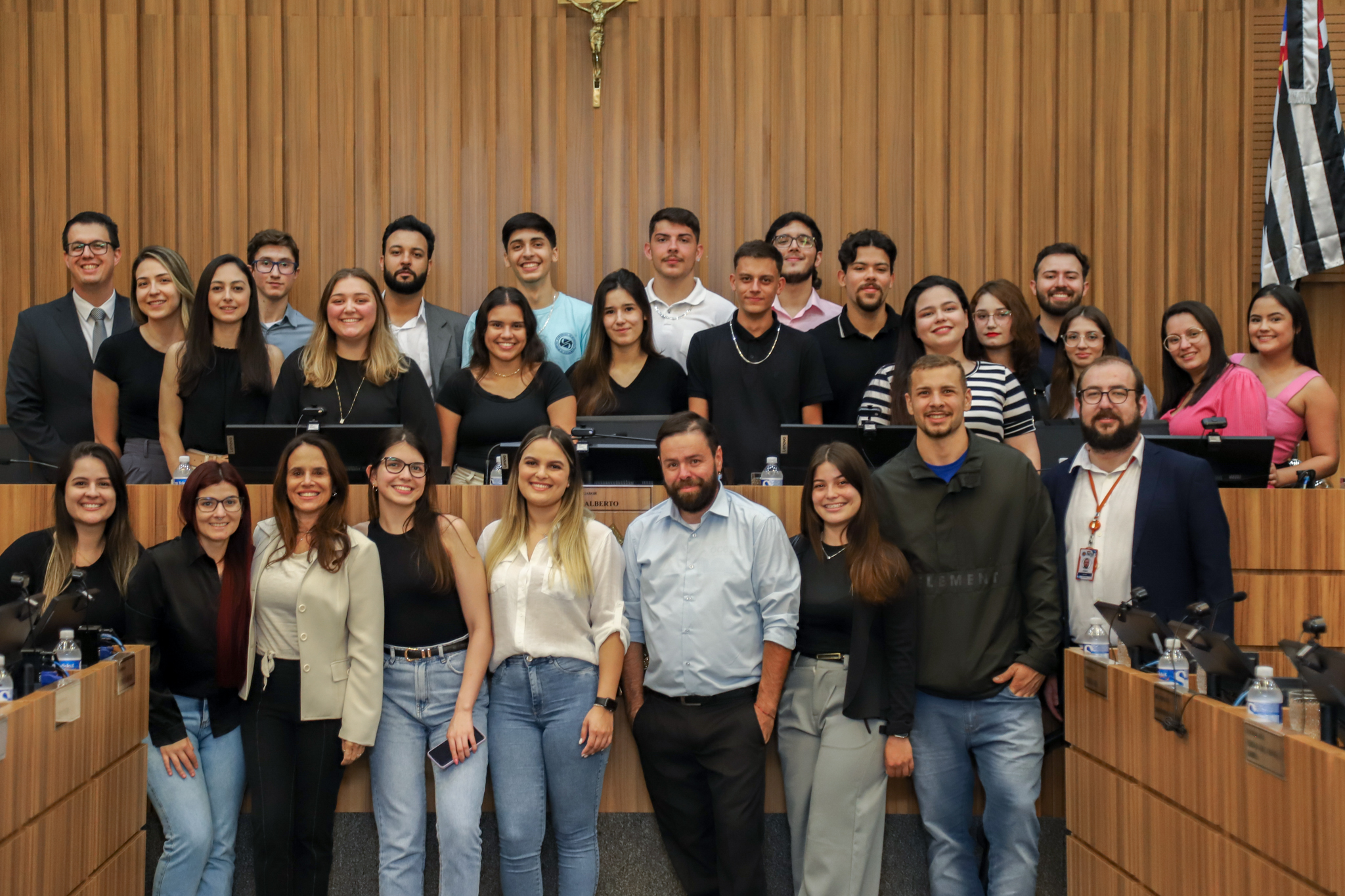 estudantes posam para foto na mesa alta do plenário ao lado da desembargadora Adriene