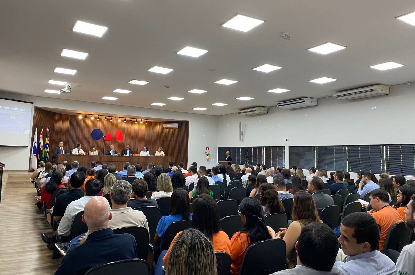 auditório da OAB de Presidente Prudente lotado. Ao fundo, o presidente Samuel está sentado à mesa de abertura com outros componentes.