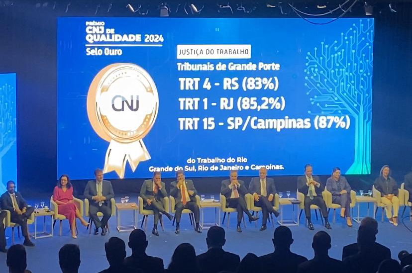 Imagem do 18º Encontro Nacional do Poder Judiciário com os vencedores do Selo Ouro projetados em telão