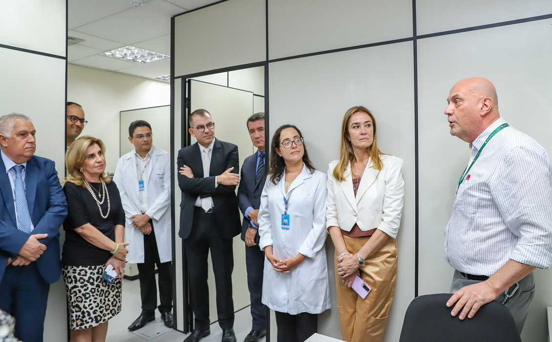 #ParaTodosVerem: em uma sala, um homem fala para um público de oito pessoas. Todos estão em pé.