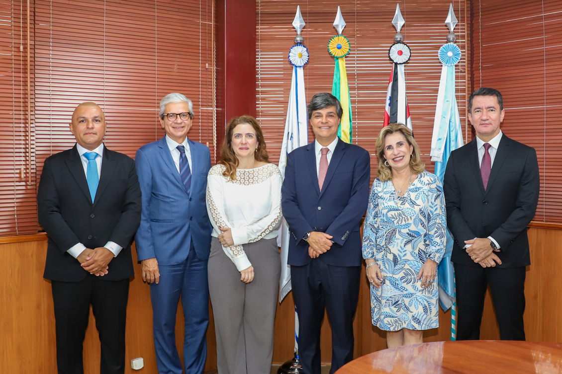 foto da comitiva da OAB com a presidente Dra. Ana Paula e o corregedor Dr. Renan, todos de pé no gabinete da Presidência, em frente as bandeiras