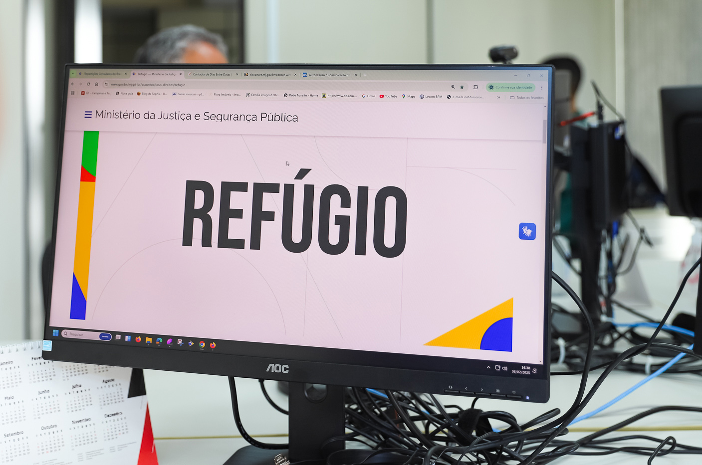 No espaço do Conare, computador exibe página do Ministério da Justiça com a palavra refúgio em tela