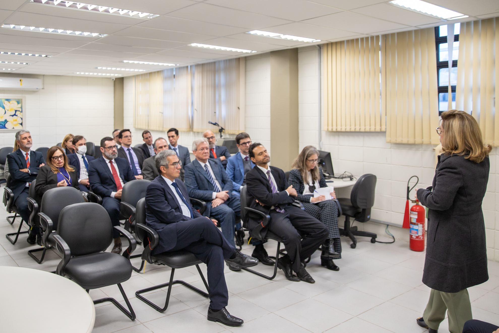 Dra. Ana Paula fala com os magistrados, que estão sentados em cadeiras numa sala do Fórum de Sorocaba