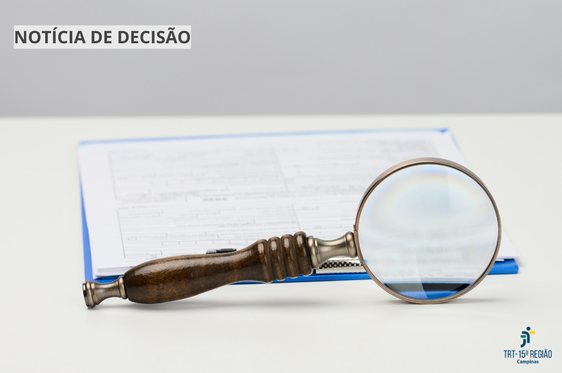 uma lupa destaca parte de um documento que está sobre uma mesa clara.