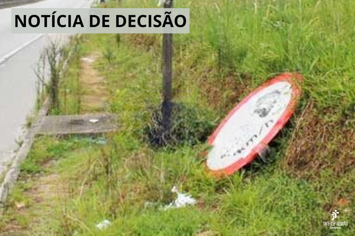 imagem de uma placa de trânsito derrubada na beira de uma estrada