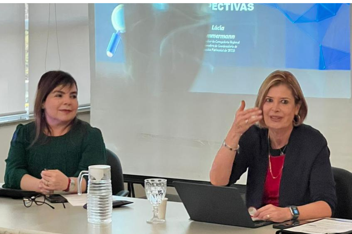 Dra. Lúcia Zimmermann e Dra. Marina de Siqueira Ferreira Zerbinatti sentadas à mesa