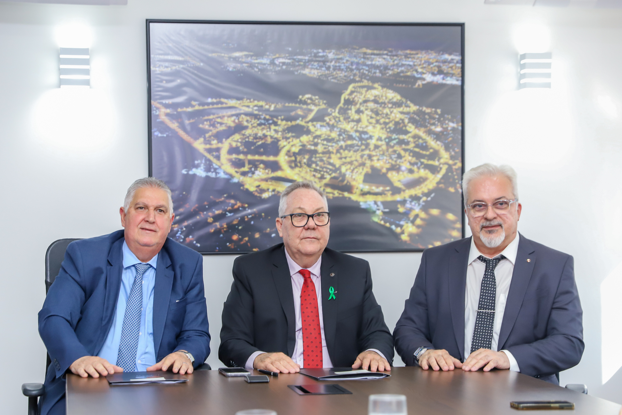 Três homens sentados à mesa