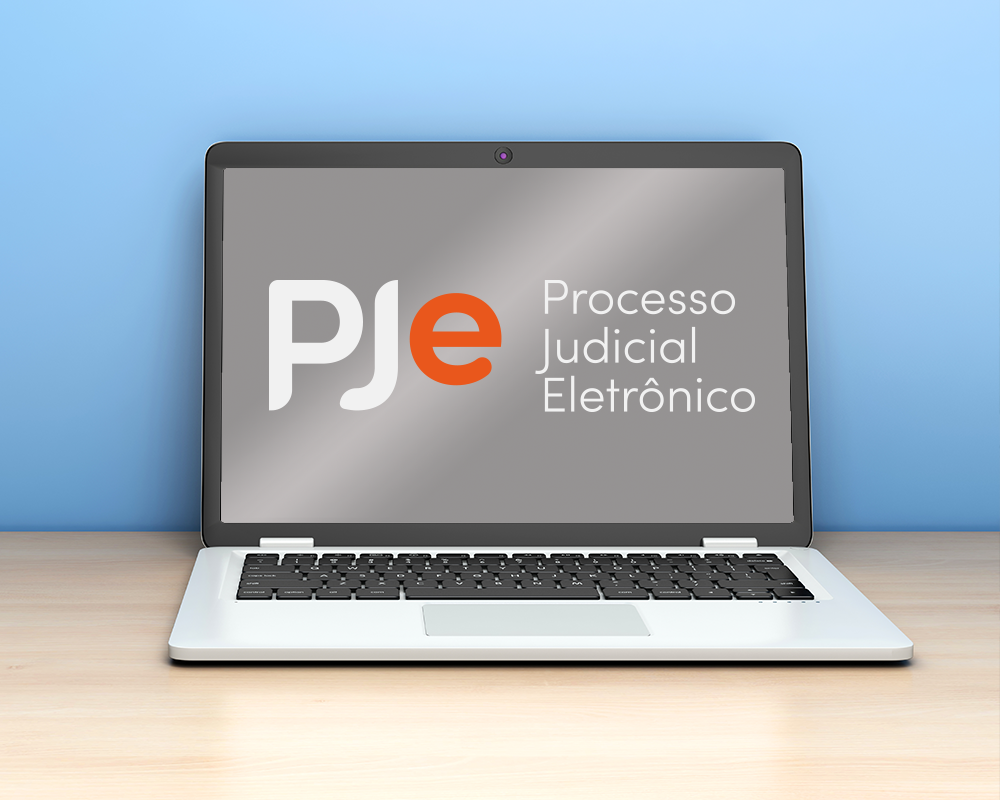 notebook sobre uma mesa com o logotipo do PJe na tela