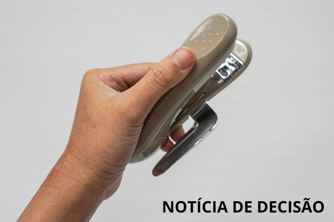 Uma mão segura um grampeador