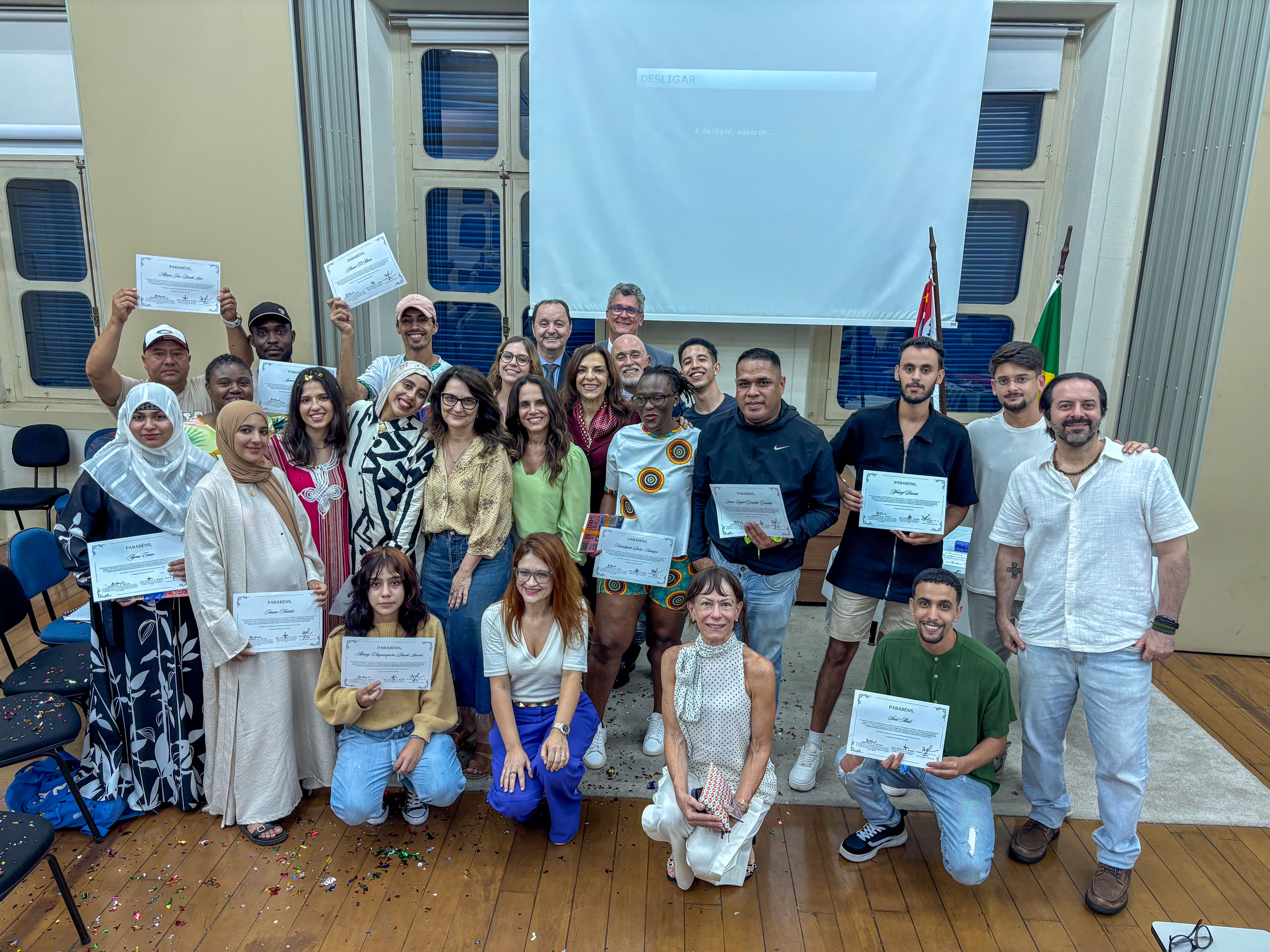 imagem de um grupo de pessoas posando para foto com certificados nas mãos