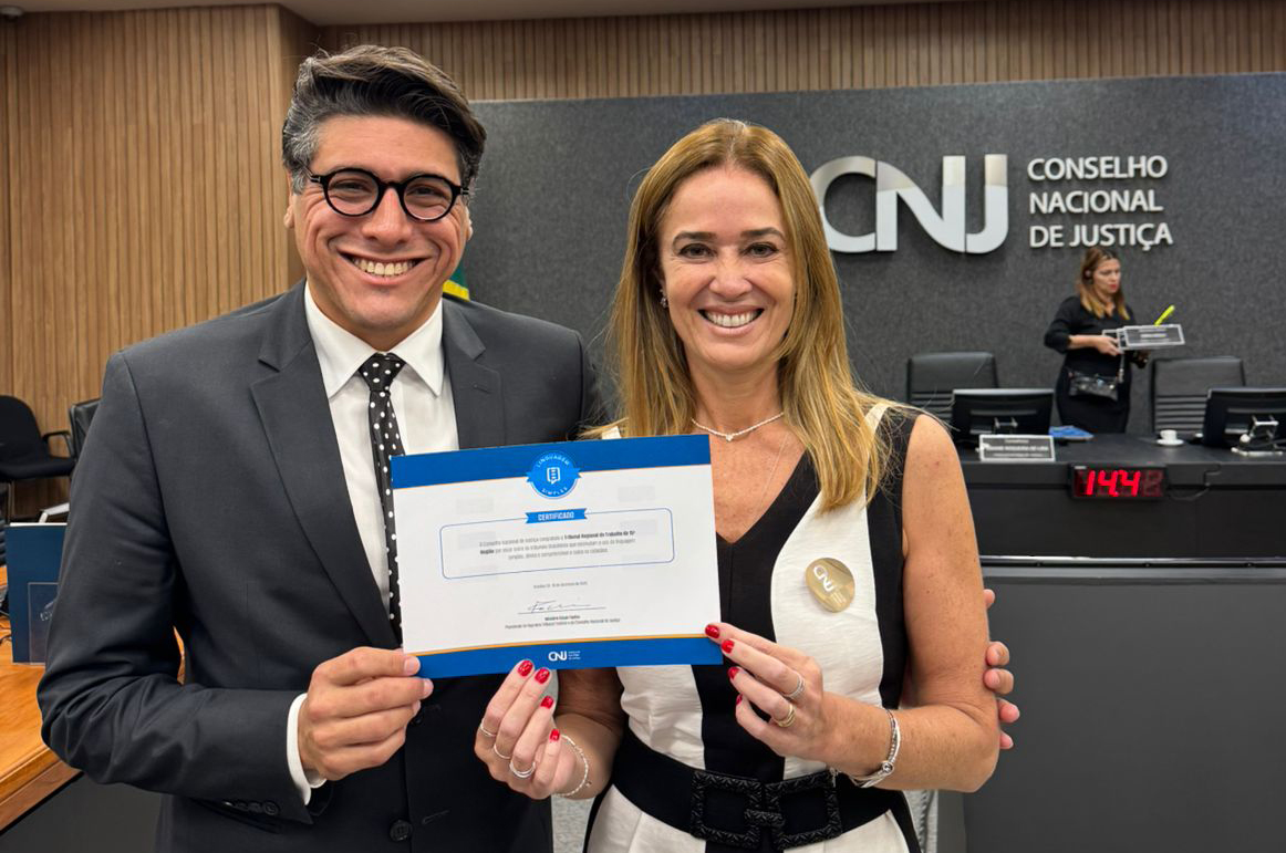 Dr. Marcel e Dra. Daniela seguram o certificado entregue pelo CNJ no auditório do órgão