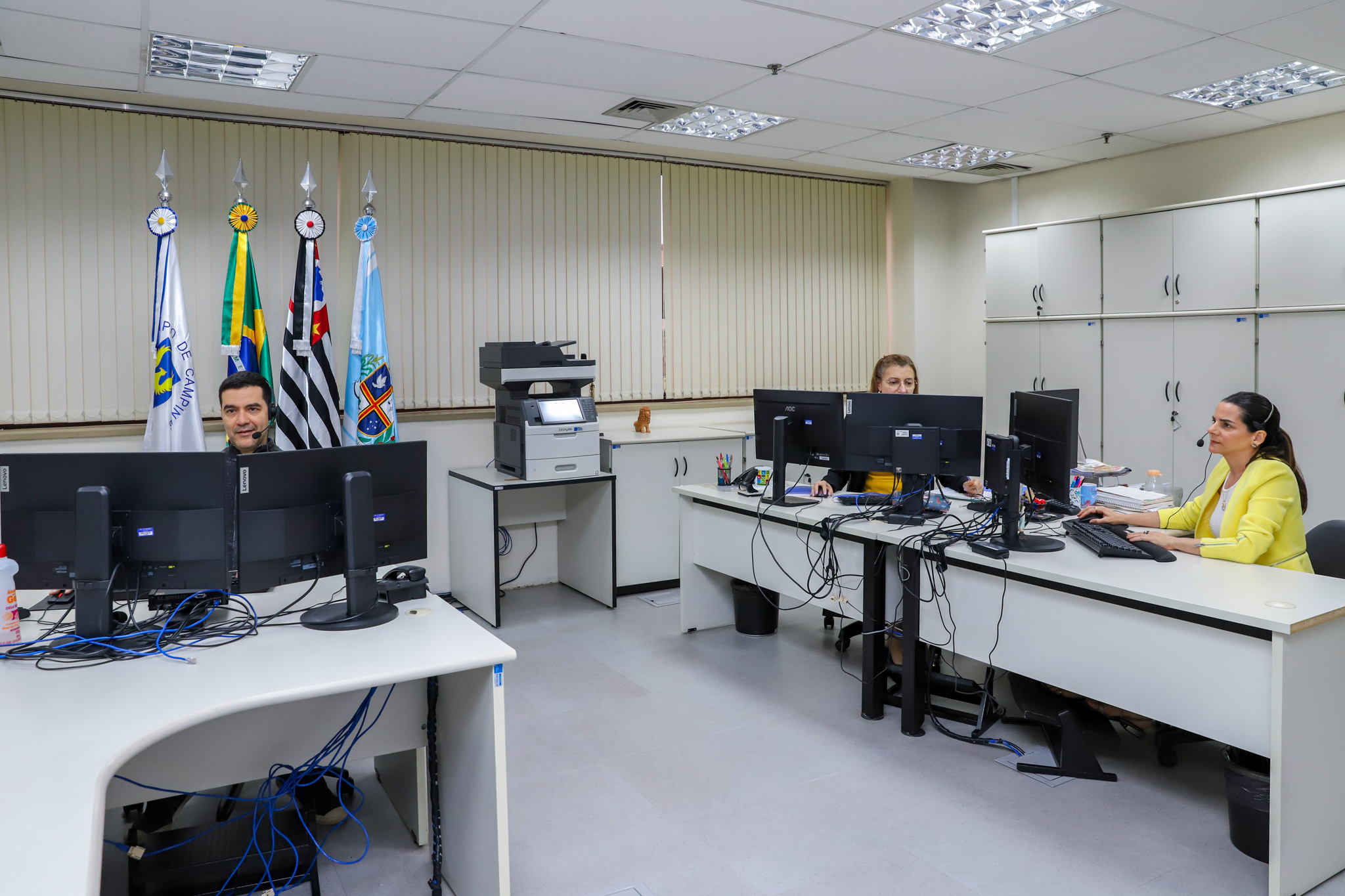 foto de um servidor e duas servidoras da Ouvidoria trabalhando em seus computadores