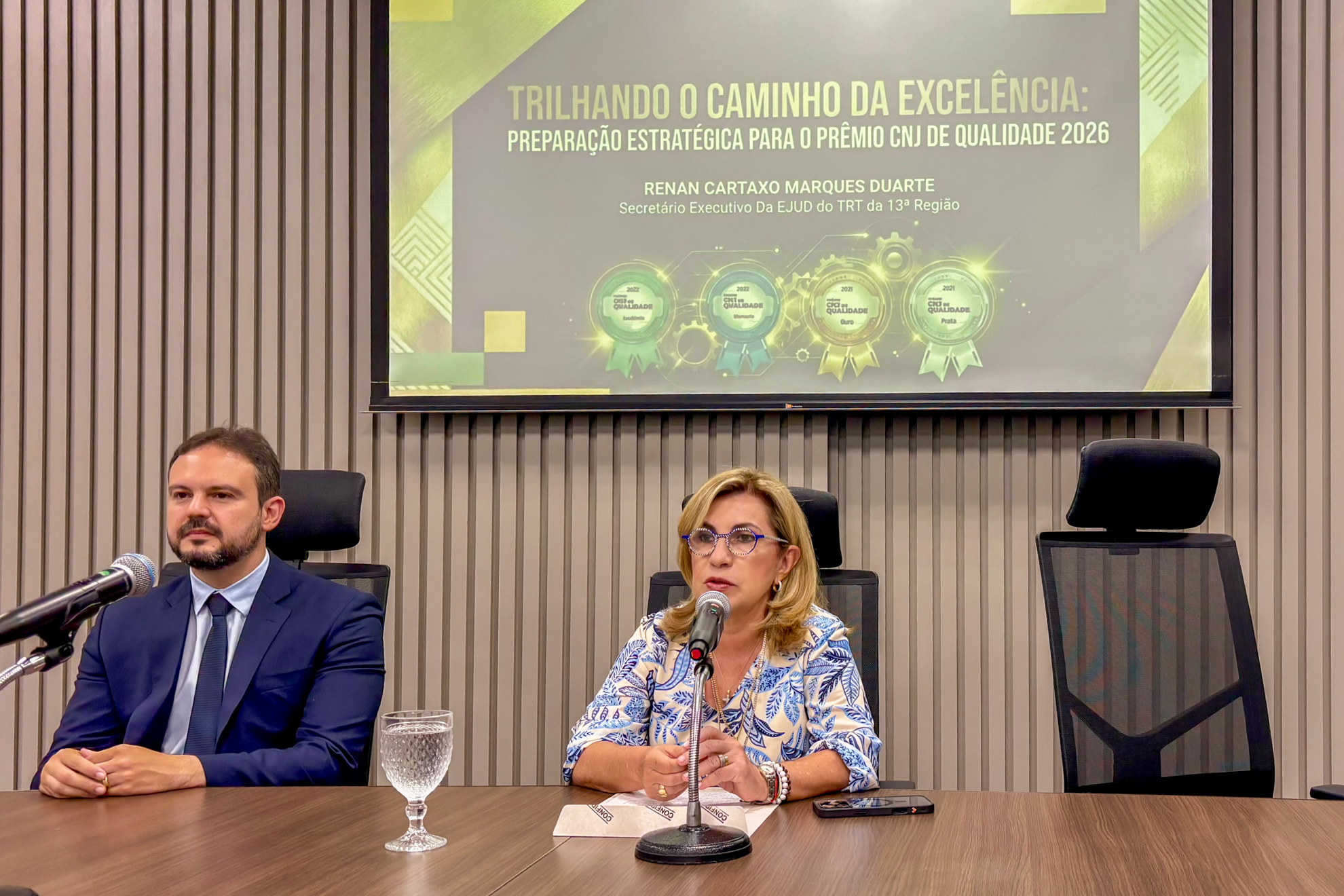 Imagem da presidente da Corte, desembargadora Ana Paula Pellegrina Lockmann  e do servidor do TRT-13 (PB), Renan Cartaxo Marques Duarte sentados à mesa
