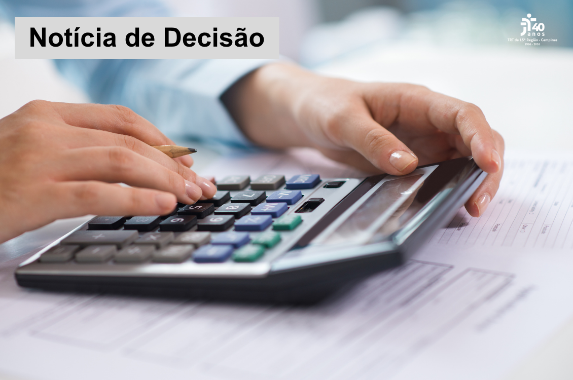 mãos femininas utilizam uma calculadora sobre papéis em uma mesa