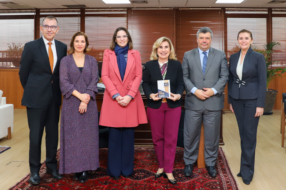 Dra. Ana Paula e demais participantes da reunião estão de pé, posando para a foto, no gabinete da Presidência