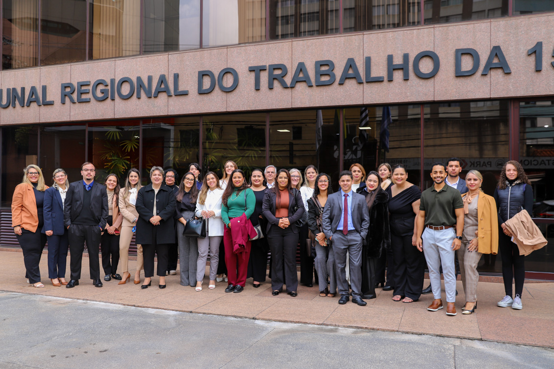 Grupo de pessoas posa para foto em frente ao prédio do TRT-15