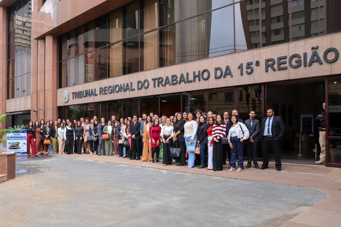 Grupo de pessoas posam para foto na frente do TRT-15.