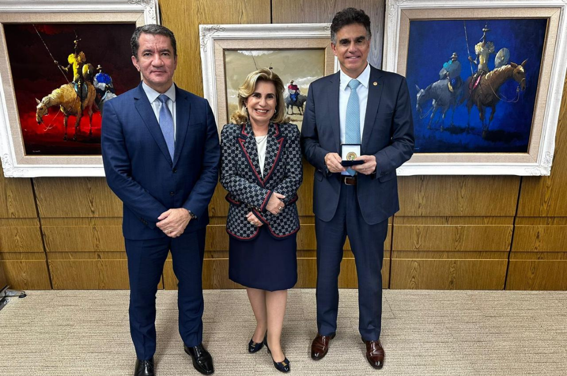 Dr. Renan, Dra. Ana Paula e ministro Vieira de Mello segurando a caixa com a medalha. Todos de pé, com quadros ao fundo