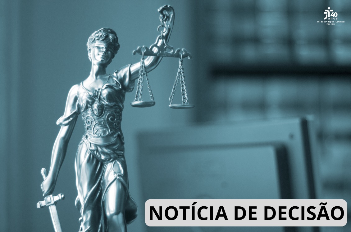 estatua da justiça, um computador e uma estante de livros ao fundo, em imagem em preto e branco