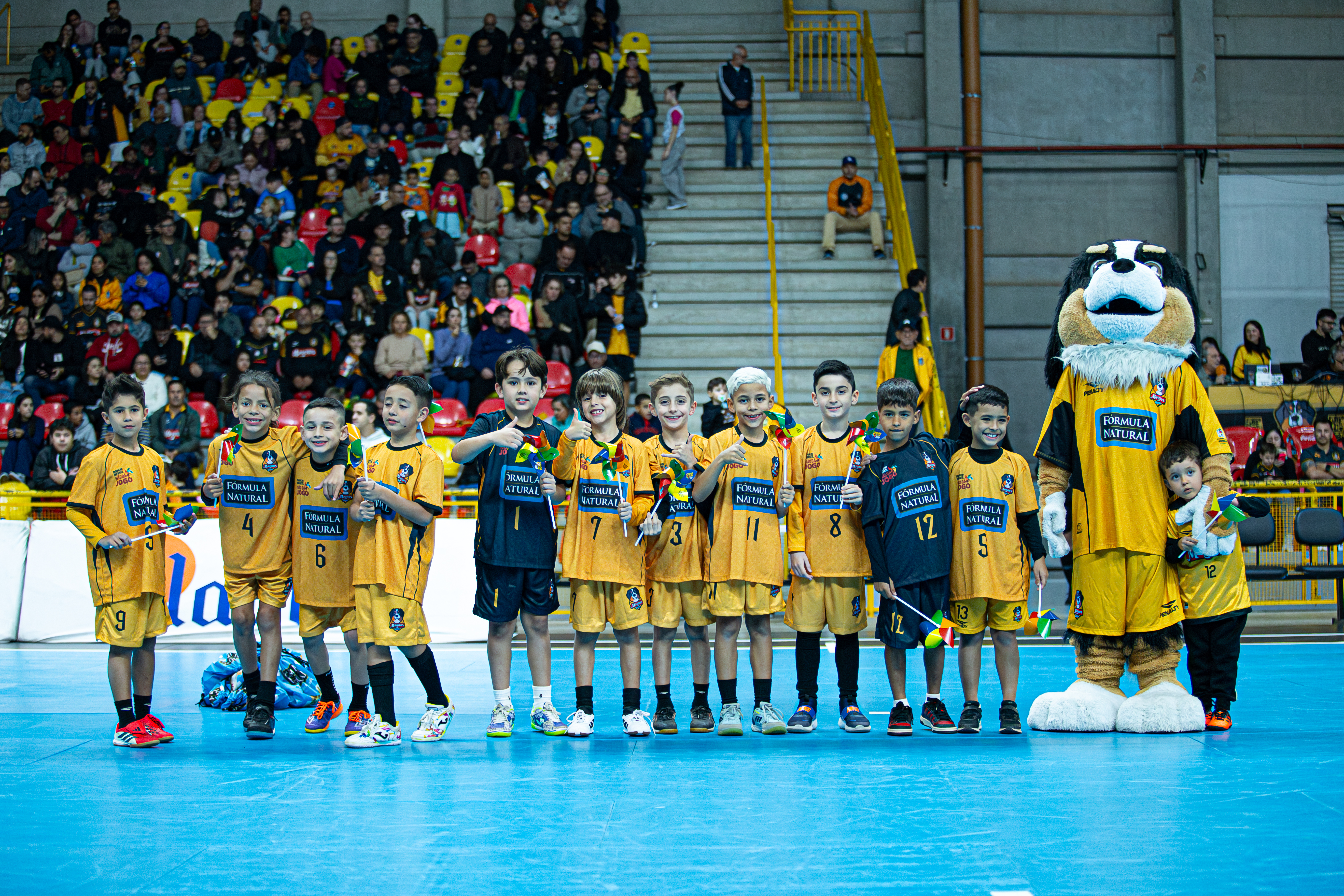 foto das crianças do futsal em quadra segurando o cata-vento alusivo ao combate ao trabalho infantil