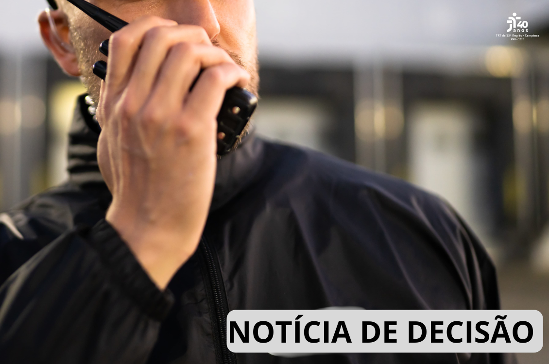 Imagem em close mostra parte do rosto e do tronco de um vigilante uniformizado, utilizando um rádio comunicador junto ao rosto. O fundo está desfocado, sugerindo um ambiente corporativo ou comercial. No canto inferior direito, há a inscrição "Notícia de Decisão" e, no canto superior direito, a marca comemorativa dos 40 anos do TRT da 15ª Região.