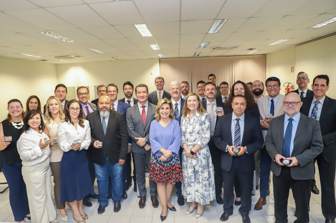 foto posada com os membros da alta administração e os juízes segurando as moedas