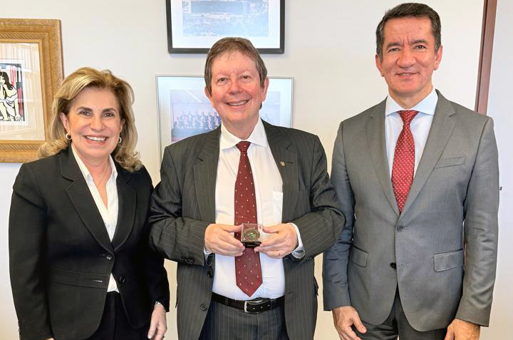 Dra. Ana Paula, o ministro José Pimenta no centro, segurando a moeda, e o Dr. Renan Ravel, posados para foto
