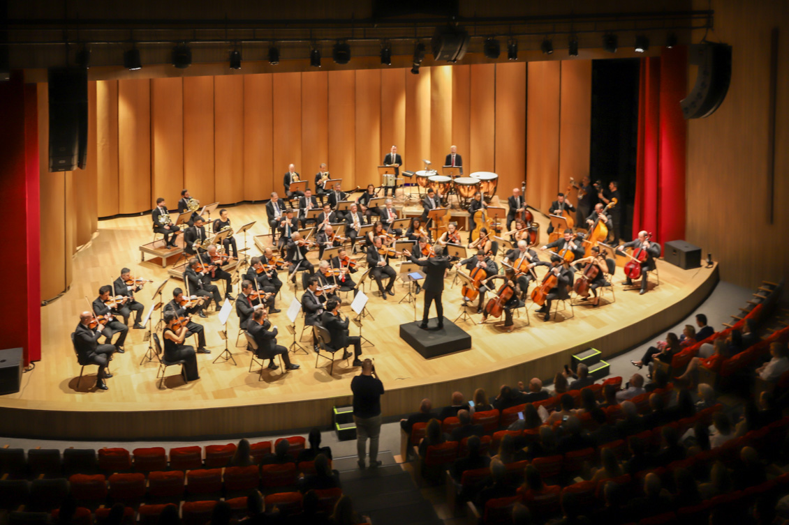 Uma orquestra se apresenta no palco do teatro.