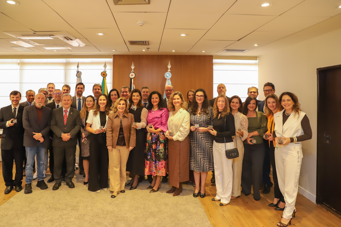 Magistrados posam para a foto cada um segurando sua moeda.