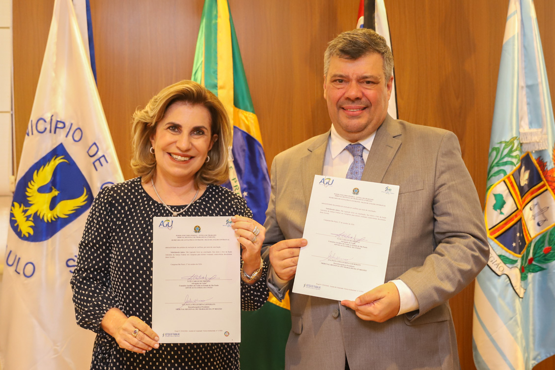 foto posada da Dra. Ana Paula e do Dr. Luiz Carlos segurando o termo assinado