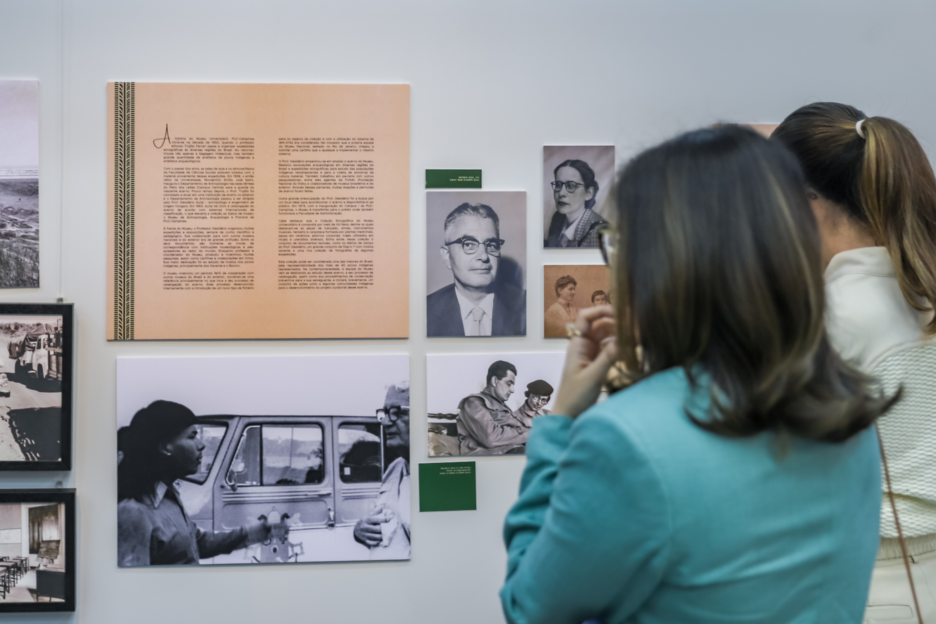 "duas mulheres observam cartas, documentos e fotografias que compõem a mostra"