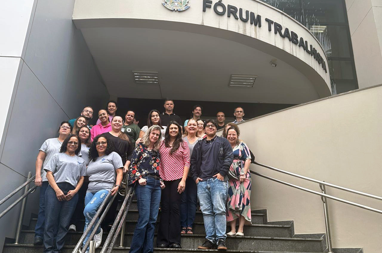 "participantes da roda de conversa de Presidente Prudente posam em pé para foto em frente a fachada do Fórum"