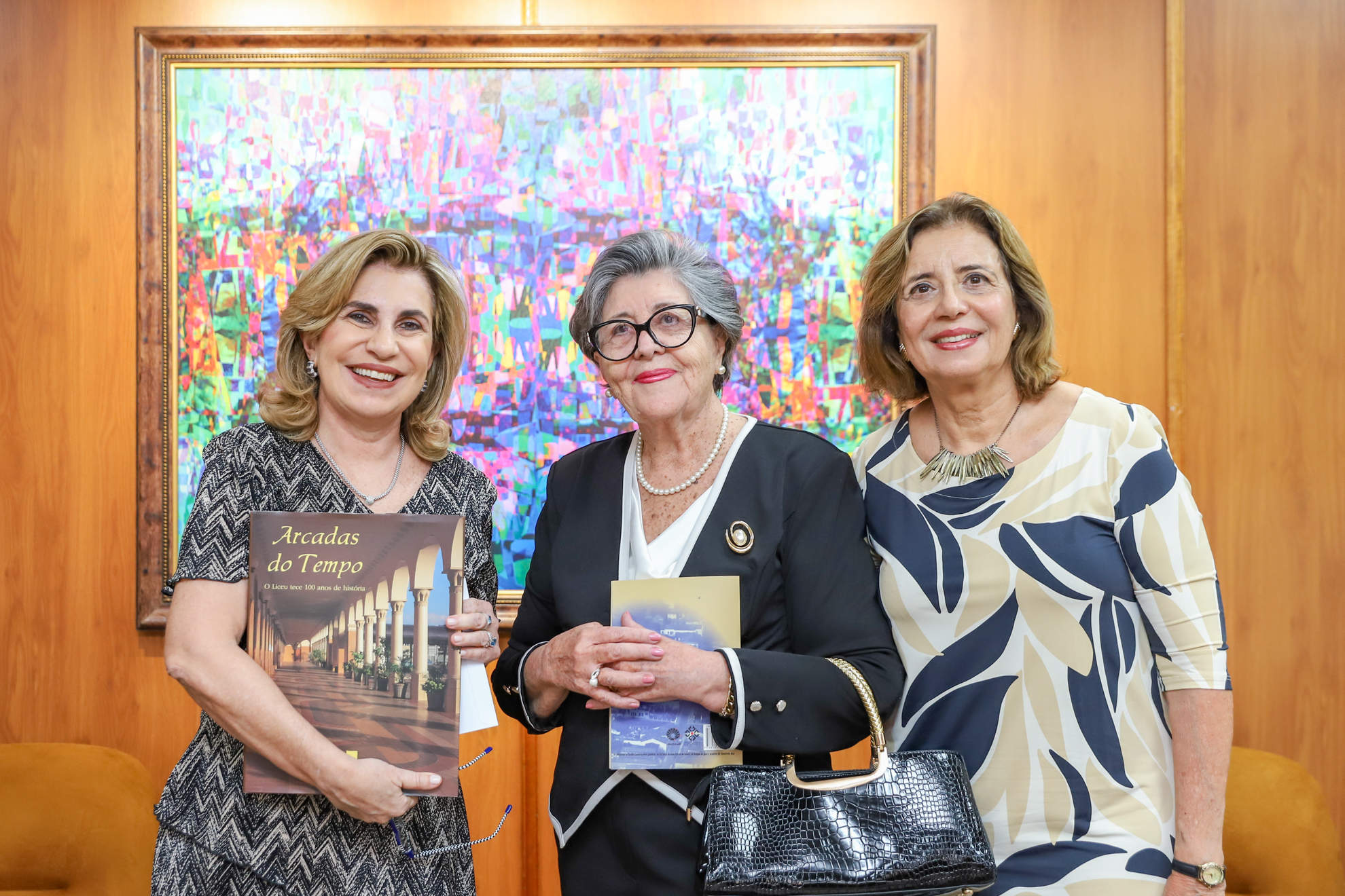 "três mulheres posam para foto"