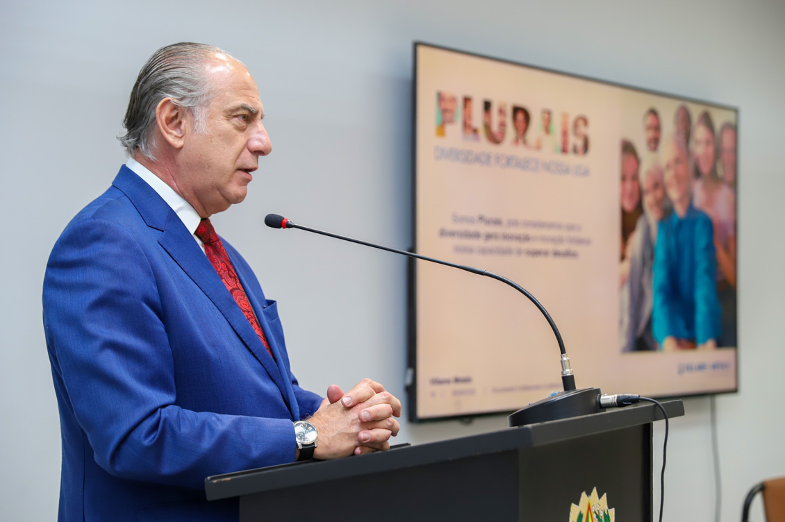 "Desembargador Fábio Aguiar está de pé no púlpito, falando ao microfone"