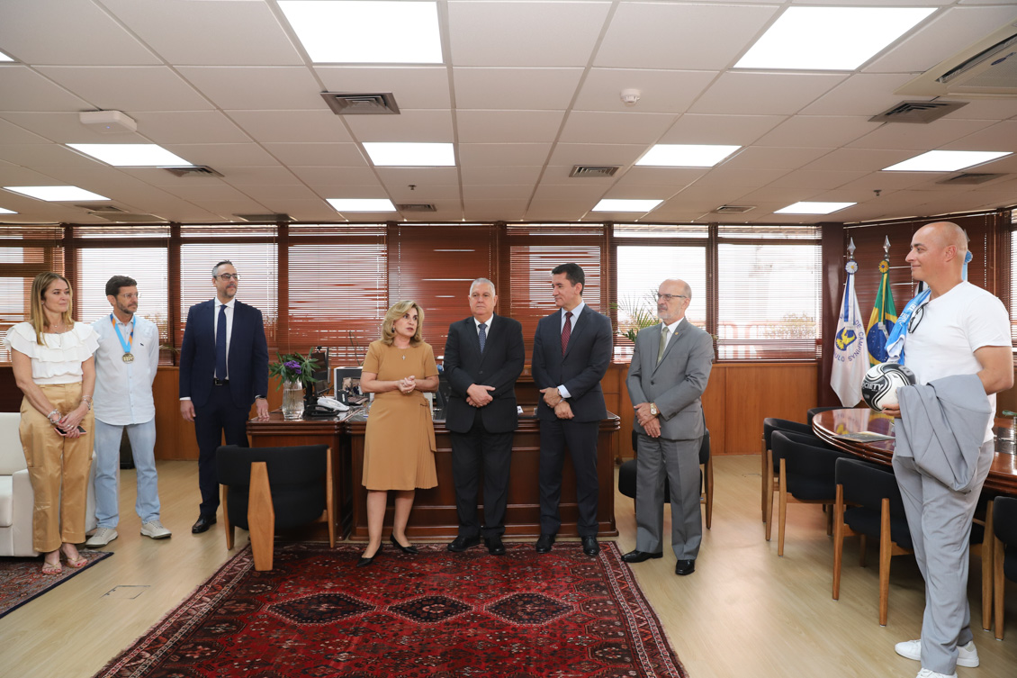 "A presidente Ana Paula em pé fala junto com os demais participantes".