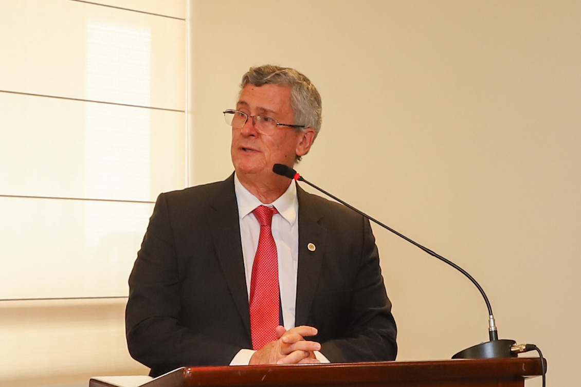 "Dr. André está no púlpito, falando ao microfone"