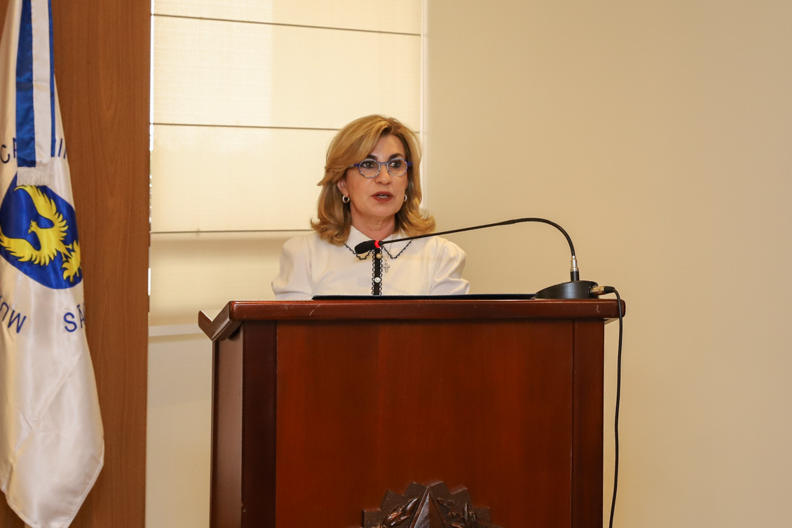 "Dra. Ana Paula está no púlpito, falando ao microfone"