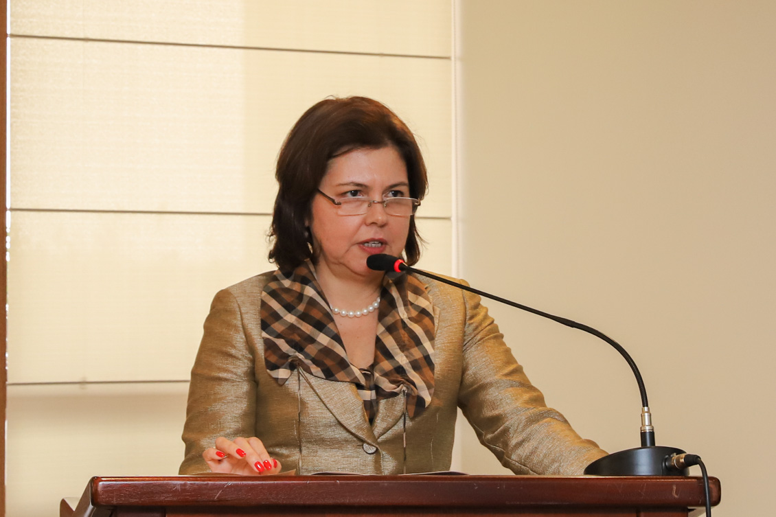 "Dra. Scynthia está no púlpito, falando ao microfone"