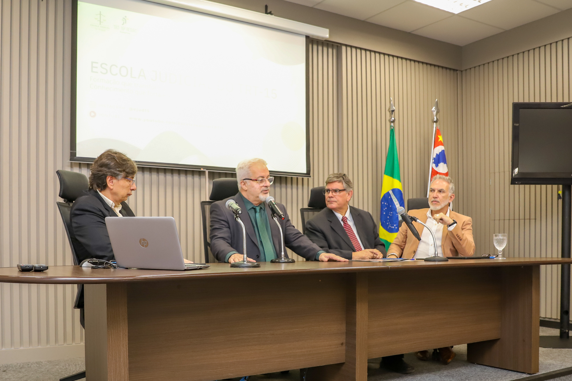 "composição da mesa alta com o Dr. Lobo falando ao microfone"