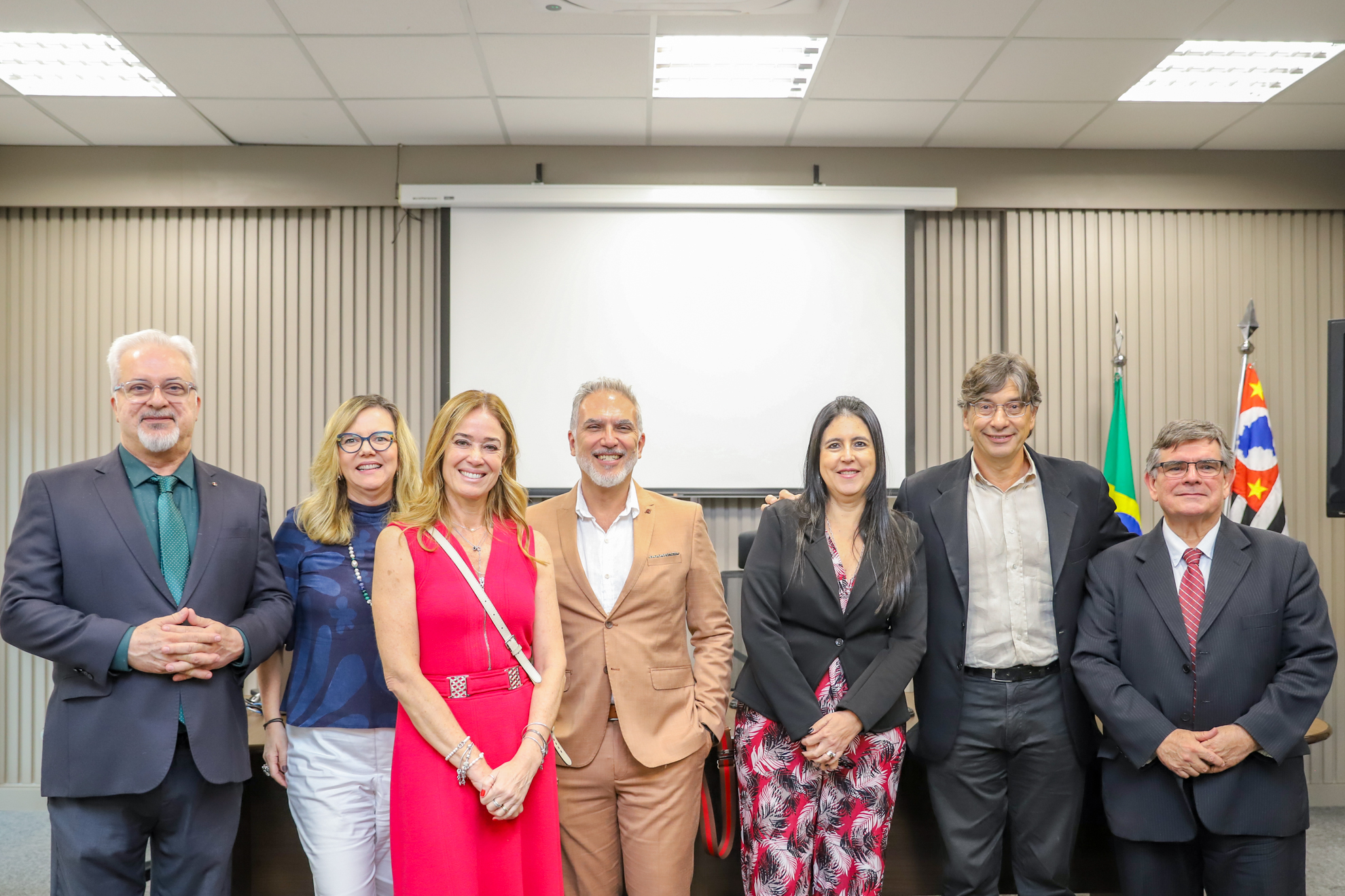 "Sete desembargadores, sendo três mulheres, posam para foto ao lado de Pochmann. Todos de pé"