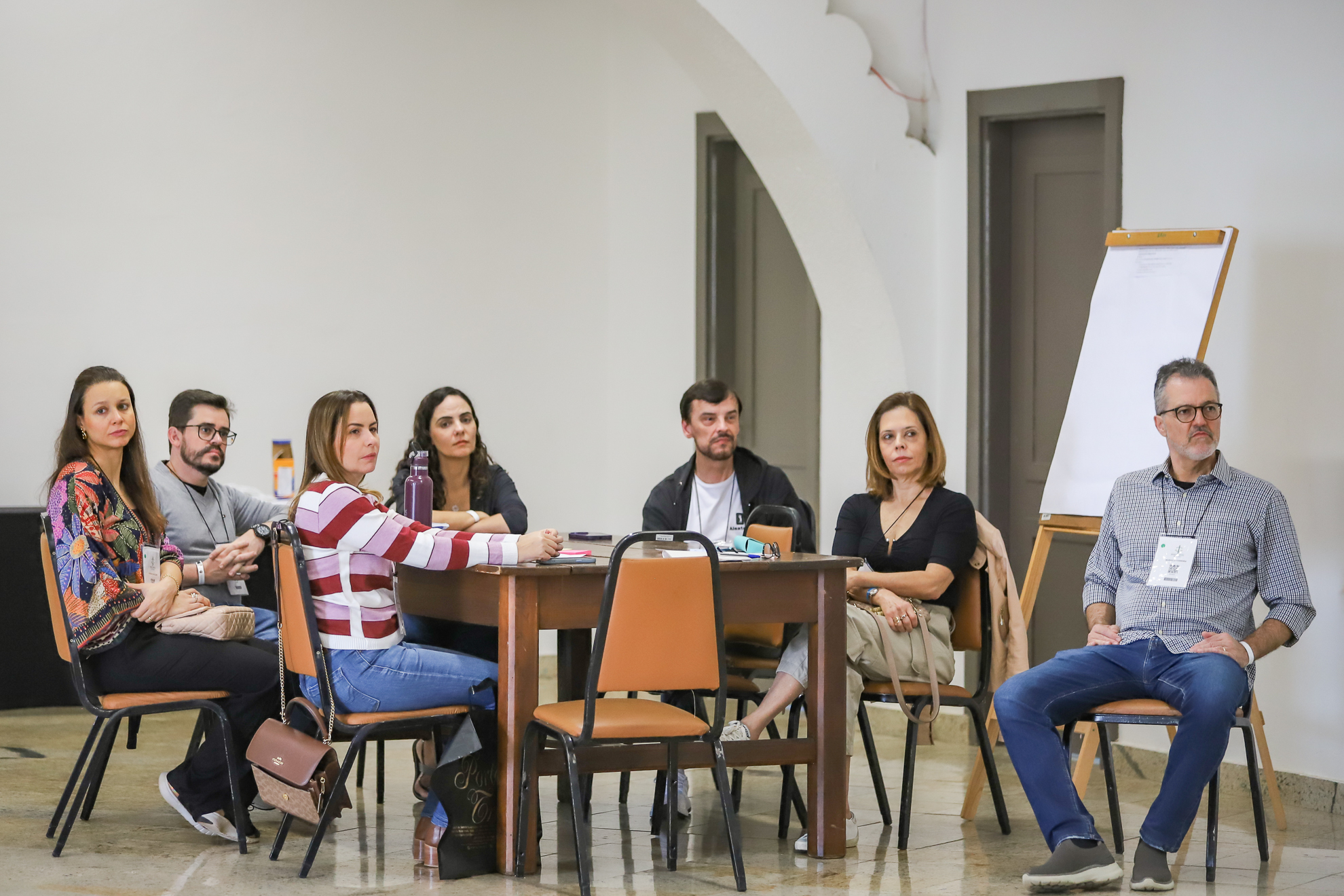 "Magistrados em grupo, sentados à mesa, participando das oficinas"