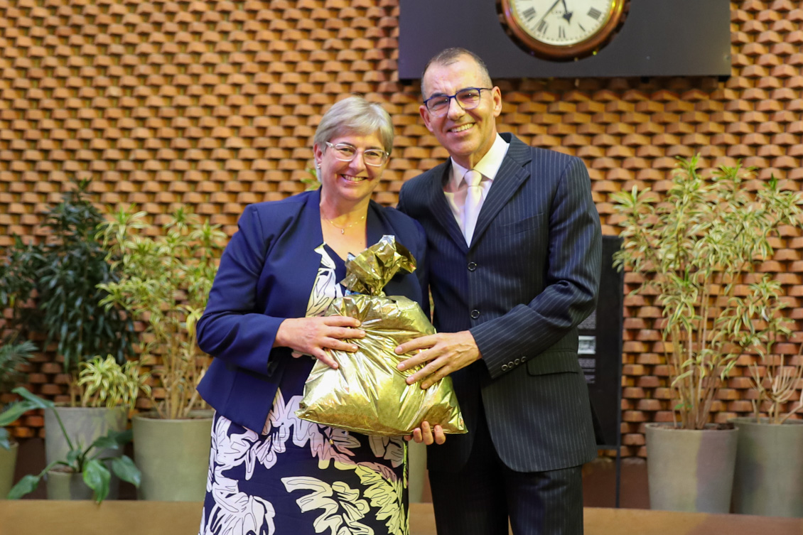 "Ana Maria segura um presente, ao lado do diretor geral do TRT-15, Adlei"