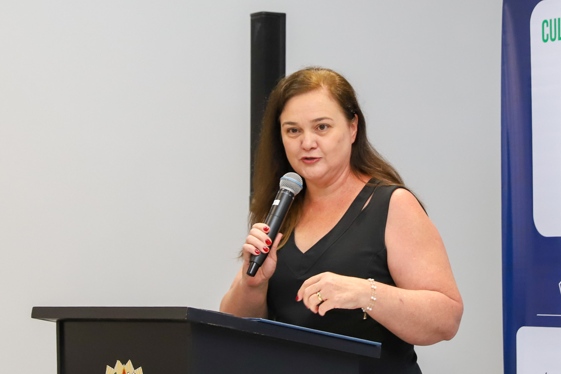 "Silvia fala ao microfone, no púlpito"